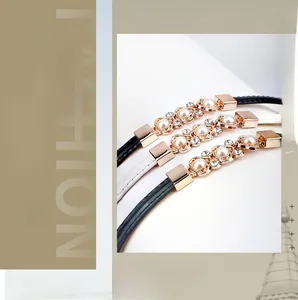 Détail de la boucle fleurie en perles et strass sur une fine ceinture de mode réglable
