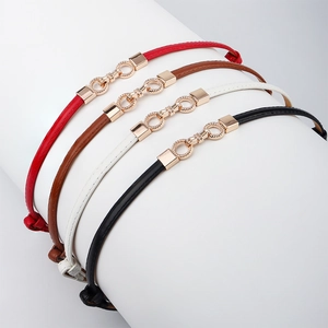 Detail view of thin waist belts in four colors with elegant golden metal buckles