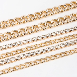 Detail of multi-layered gold curb chains and sparkling rhinestone tennis chains