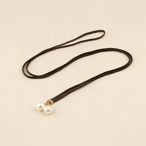 Detail of bohemian black woven waist rope featuring elegant double pearl pendants