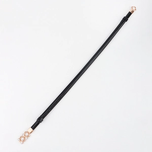 Détail de la fine ceinture noire avec boucle à fleurs rose doré et perles blanches