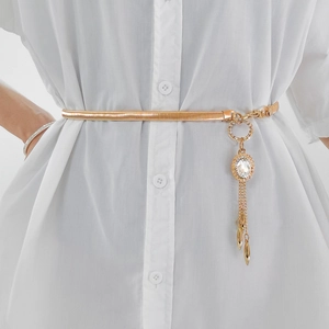 Detailed close-up of golden elastic waist chain with crystal pendant and metallic tassels