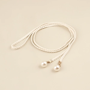 Macro detail of bohemian braided thin waist rope with polished white pearl pendants