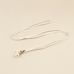 Detail of white braided waist rope with polished pearls and gold metal accents