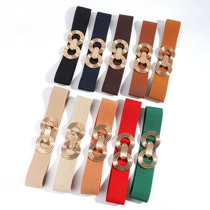 Women's elastic waist belt with interlocking gold geometric buckle in multiple colors