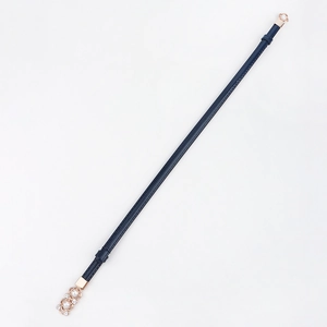 Détail d'une ceinture fine bleue avec boucle en or rose ornée de perles et de strass