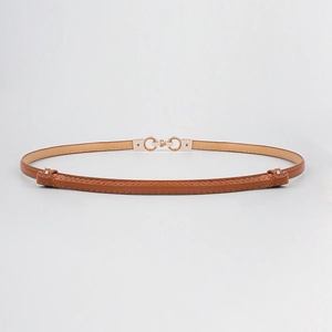 Detail of slim brown leather belt with elegant golden double-ring buckle for dresses