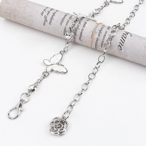 Detailed shot of silver butterfly and rose pendants on a rhinestone waist chain belt