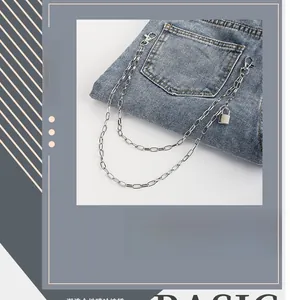 Detail of silver double-layered metal trousers chain with square padlock on blue denim jeans
