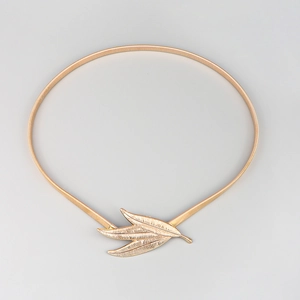 Detailed macro view of the three-leaf golden buckle on a metallic elastic waist belt