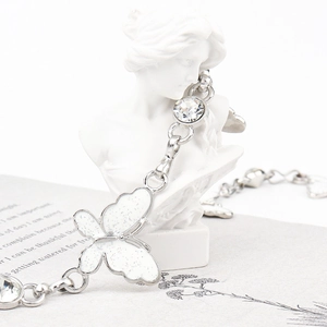 Silver waist chain with white glitter butterfly pendant displayed on a female bust statue