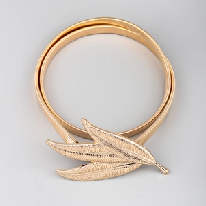 Detail of golden metal elastic belt showing intricate triple leaf design and spring texture
