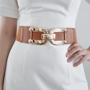 Detail of golden double-ring buckle and brown leather on women's wide elastic waist belt