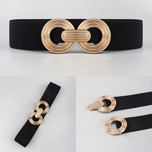 Detail of black elastic belt featuring a decorative interlocking gold metal buckle