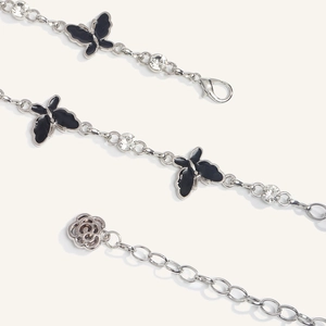 Detail of silver waist chain featuring black enamel butterflies and sparkling round crystals