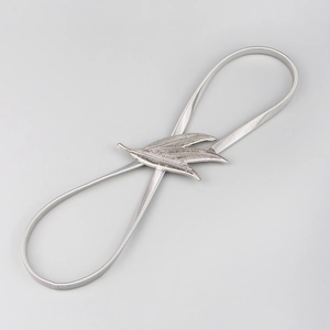 Detailed close-up of three metallic silver leaf buckles on an elastic metal waist belt
