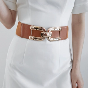 Detail of a brown elastic wide waist belt with a large gold double-ring metal buckle