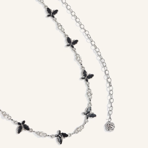 Detail of silver chain belt with black butterfly charms, rhinestones and rose pendant