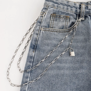 Detail view of triple-layered punk metal pants chain with padlock on denim jeans