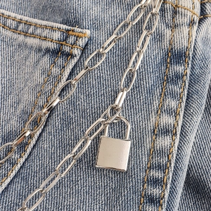 Detailed close-up of a silver punk pant chain with a polished rectangular padlock pendant