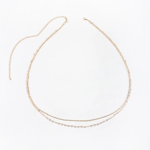 Detail of golden double-layer body chain with heart-shaped links and lobster clasp