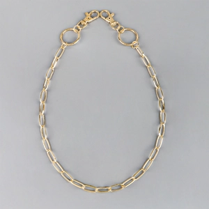 Close-up of golden hollow metal chain links with secure lobster clasps for pants