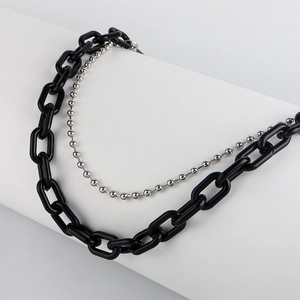 Detail view of punk style double-layered chain featuring black resin and silver beads