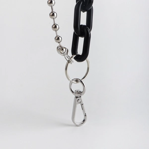 Detail of silver bead chain and black acrylic ring chain connected with a metal lobster clasp