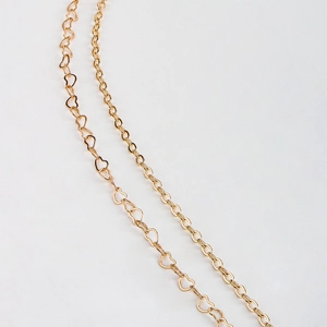 Macro view of double-layer gold heart-shaped hollow metal chain link details