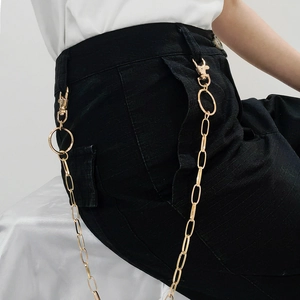Detailed view of the gold hollow chain on black cargo pants with punk hip hop style hooks