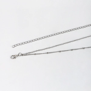 Détail d'une chaîne de corps argentée à double rang avec fermoir mousqueton réglable