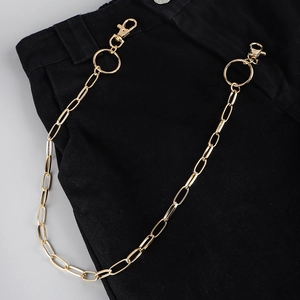 Close-up of gold punk hip-hop waist chain with lobster clasps on black denim jeans