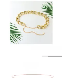 Detail view of chunky gold-tone hollow metal chain belt with extension and drop charm