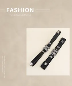 Détail de boucles argentées ciselées sur ceintures punk noires et bandes élastiques
