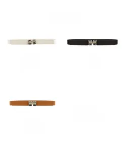 Détail des ceintures élastiques avec boucles métalliques géométriques en blanc, noir et brun