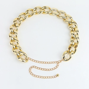 Detail of chunky gold metal waist chain with adjustable lobster clasp and polished finish