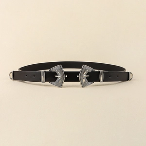 Détail des doubles boucles argentées de style western avec motifs géométriques sur ceinture