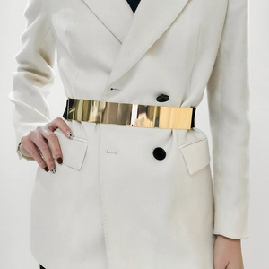 Close-up of gold metal waist belt set paired with a white double-breasted suit