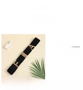 Detail of black elastic belt with golden metal F and A buckles for pants