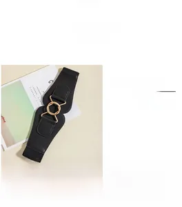 Detail showing the gold alloy circular buckle and black elastic fabric of the wide waist belt