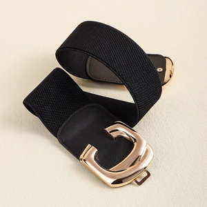 Close-up of black elastic waist belt featuring a polished gold-tone C-shape metal buckle
