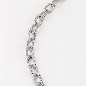 Detail view of silver hollow chain links with textured twisted rope pattern design