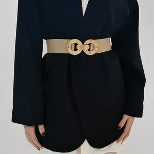 Detail of champagne gold elastic waist belt with textured metal double ring buckle