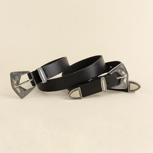 Détail de ceinture vintage en cuir noir avec boucles argentées et gravures géométriques