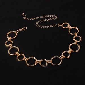 Detail of gold metal waist chain featuring textured interlocking rings and lobster clasp