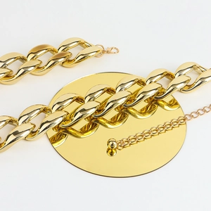 Close-up of golden interlocking chain belt with lobster clasp and adjustable tail chain
