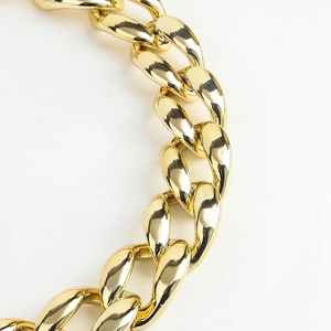 Detail of chunky golden cuban chain belt with high-polish finish and hollow punk style