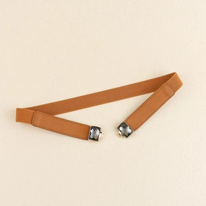 Détail de la ceinture élastique marron avec boucle ornée de pierres carrées grises