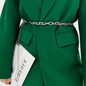 Close-up of a stylish silver metal chain belt worn over a green blazer for women