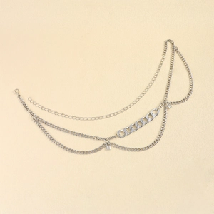 Detail of silver multilayer waist chain featuring mixed links and rectangular accents